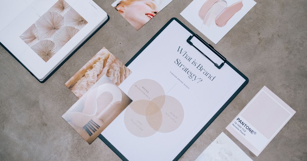 Flatlay of brand strategy documents, a mood board, and colour swatch cards on a clipboard, used to plan a brand identity